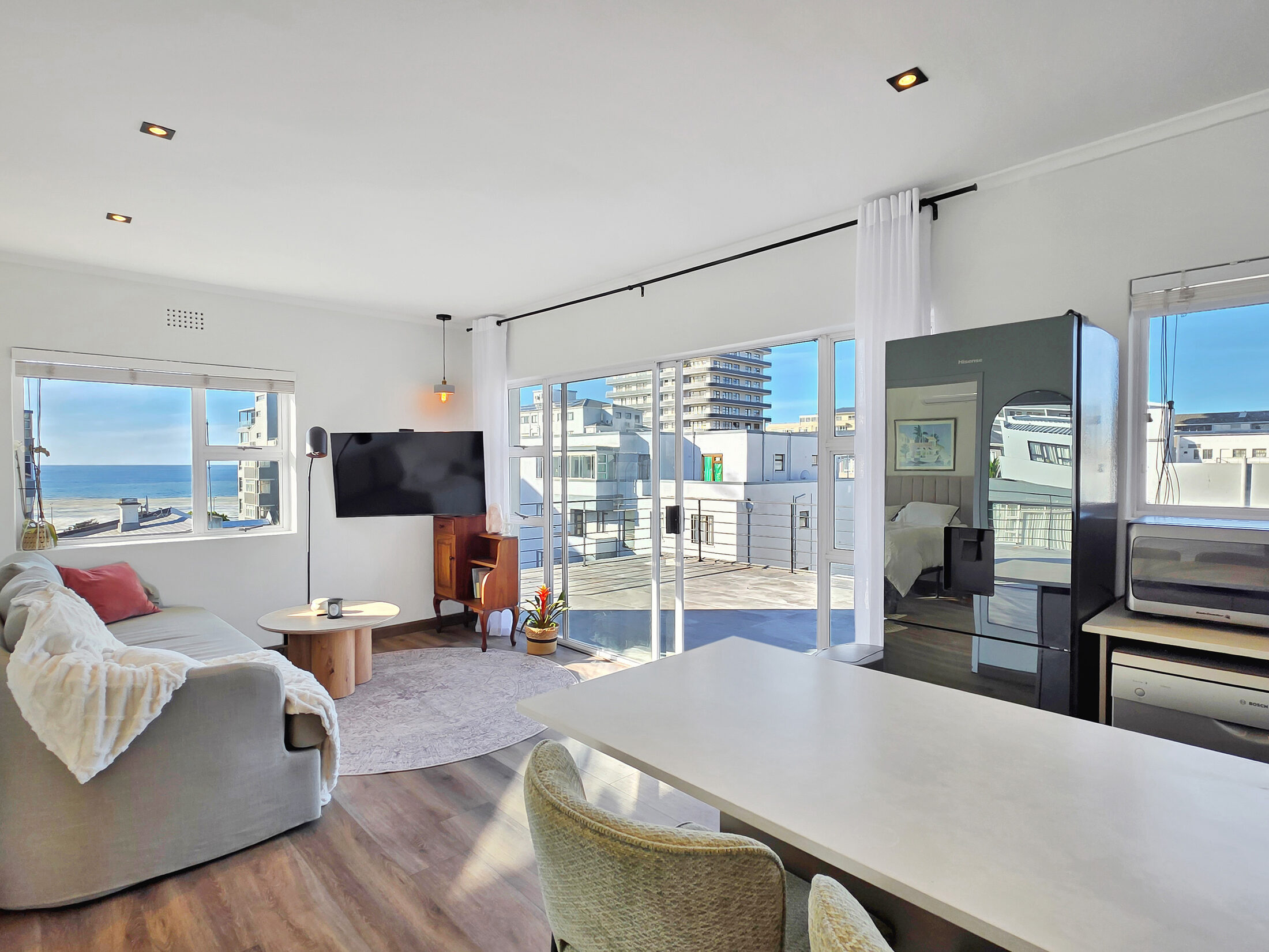 14 Plomarion's sunlit open-plan living room with city and Atlantic views